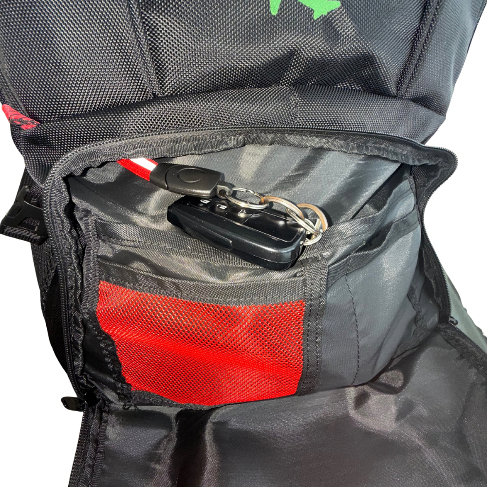 Black backpack with a red pocket and keychain inside, on a white background